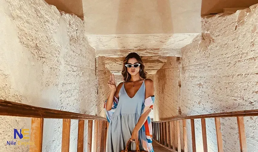 Viajera en el estrecho corredor de una tumba antigua con una pasarela de madera
