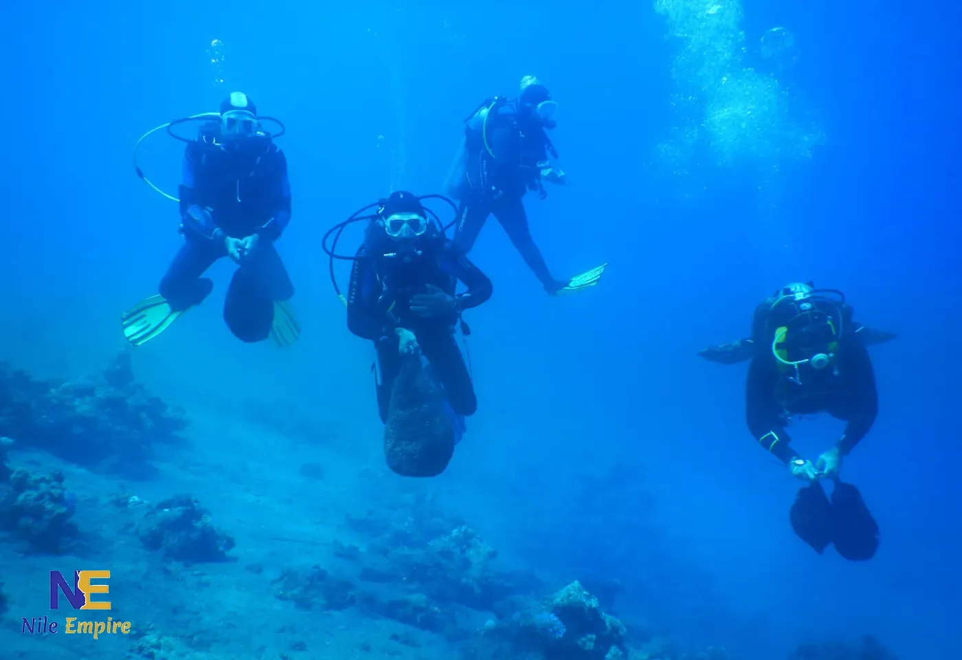 A diving instructor carefully guiding a beginner diver underwater, demonstrating the safety protocols used in the Red Sea