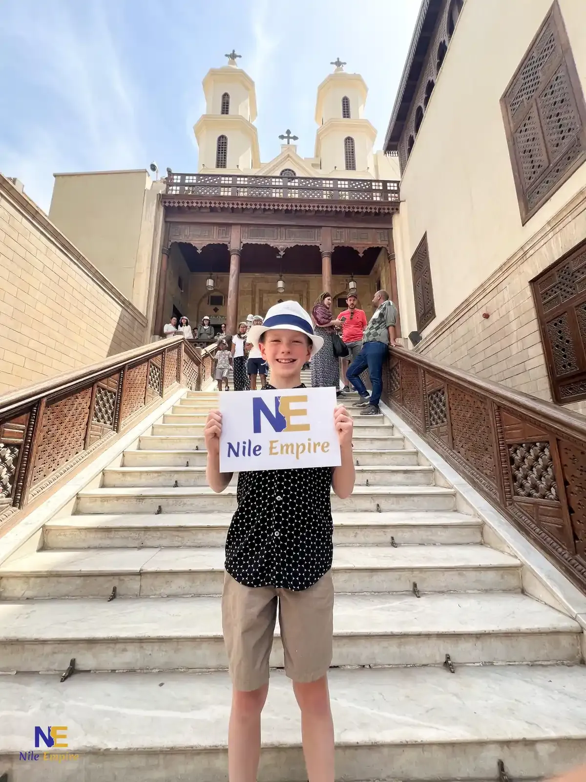 A young traveller holding a tour sign on the staircase of the Hanging Church in Cairo